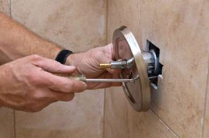 Joe installas a new low flow shower head in a customers bathroom